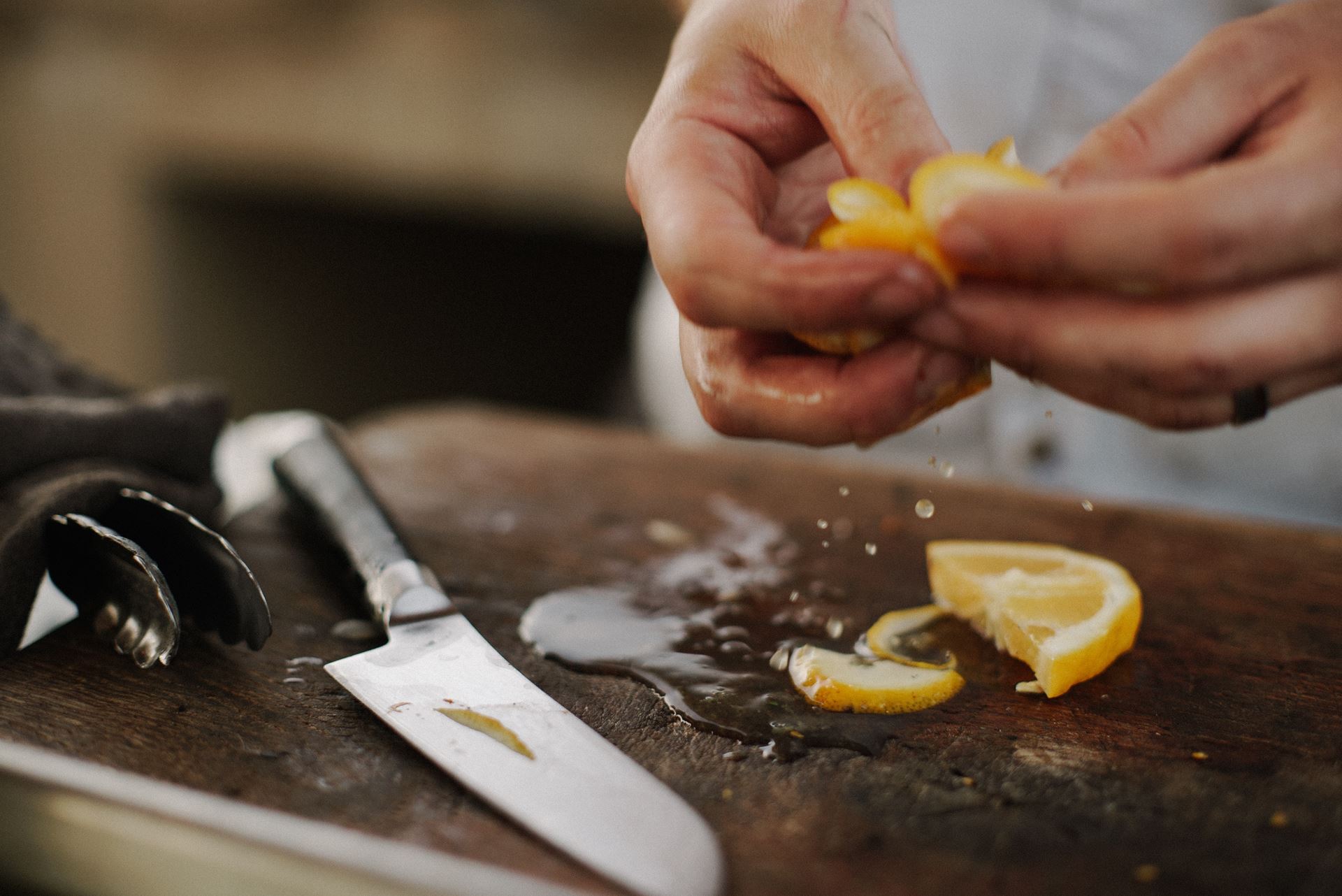 a hand holding a fork and knife on a cutting board